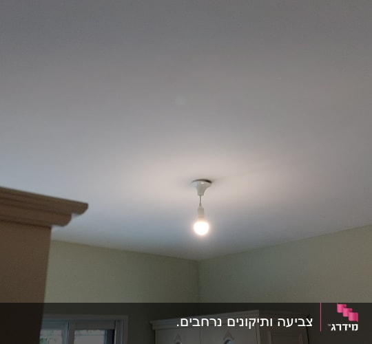 נורה תלויה מהתקרה בחדר מואר